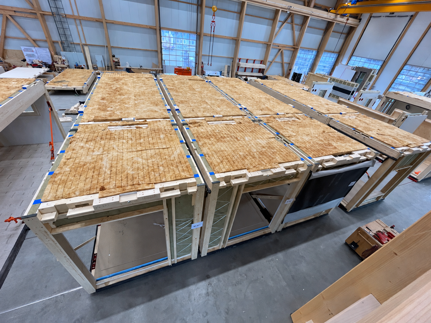 Werkstattboden zwischen Holzmodulen und Kran
